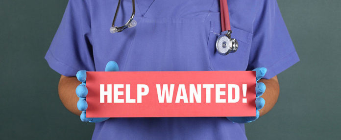 Doctor holding help wanted sign