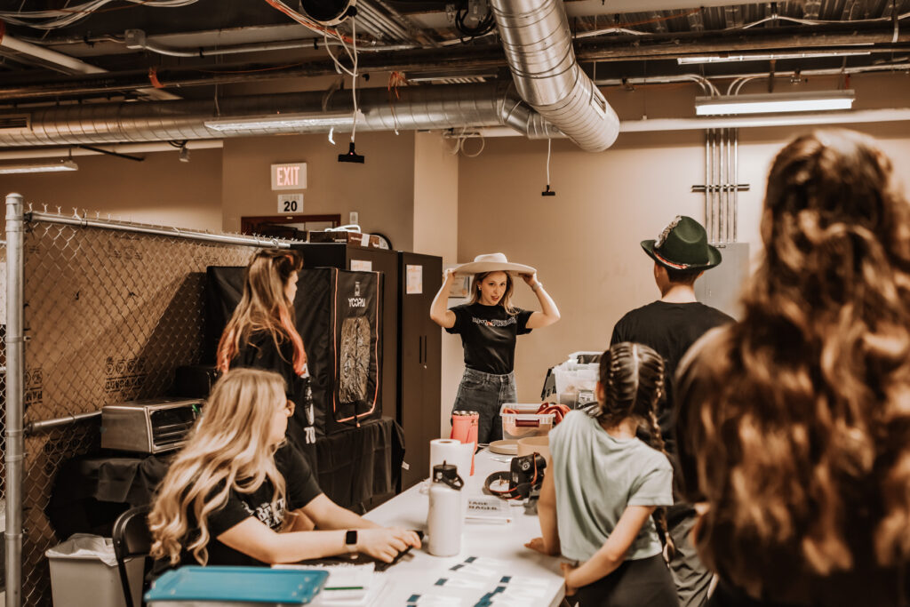 An actress trying on a hat.